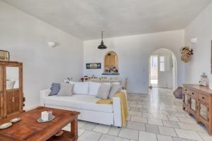 a living room with a white couch and a table at Big Blue Sunset View in Angairiá