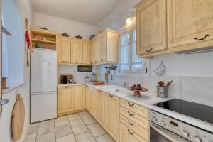 a kitchen with wooden cabinets and a white refrigerator at Big Blue Sunset View in Angairiá +8 photos