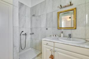 a bathroom with a shower and a sink and a mirror at Big Blue Sunset View in Angairiá