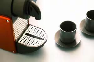 three coffee cups on saucers next to a coffee maker at ComeCasa No ZTL Alfieri Urban Stay in Asti