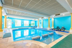 a large swimming pool with blue walls and columns at Abbey Lawn Hotel in Torquay