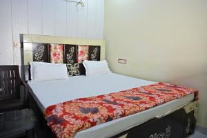 a bedroom with a large bed with a red blanket at Royal Mac Palace in Motīhāri +4 photos