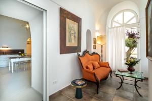 a living room with an orange chair and a table at Dimora Filangieri in Massa Lubrense