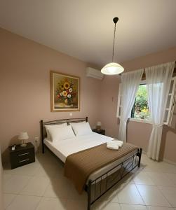 a bedroom with a bed and a window at The Kefalonian Divarata House in Kefalonia