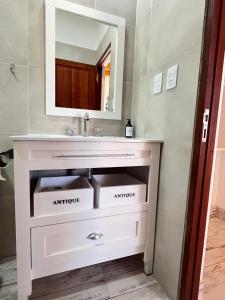 a bathroom with a sink and a mirror at Posada Suri Huasi in Tilcara