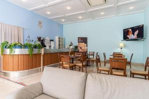 a living room with a couch and a table and chairs at Amadei Hotel Promenade in Pesaro
