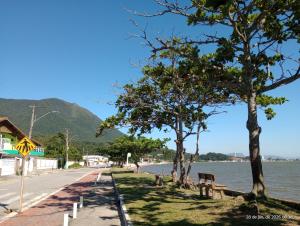 a street with trees on the side of a body of water at Recanto dos Sabiás in Palhoça