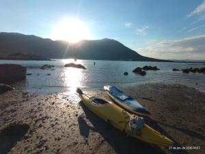 a yellow kayak sitting on a beach next to the water at Recanto dos Sabiás in Palhoça