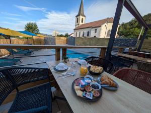 a table with a plate of breakfast food on a balcony at Hotel du Haut du Roc Demi Pension Comprise in Basse-sur-le-Rupt