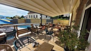 an outdoor patio with tables and chairs and a pool at Hotel du Haut du Roc Demi Pension Comprise in Basse-sur-le-Rupt