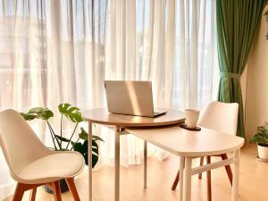 a laptop computer sitting on a table in front of a window at Maison Lumière in Odawara
