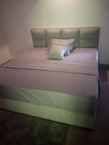a bed with white sheets and pillows at Arhh castle in Ginigathena