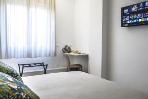 a bedroom with a bed and a table and a tv at Ciauru al Sud in Messina