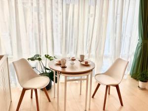 a table and two chairs in front of a window at Maison Lumière in Odawara