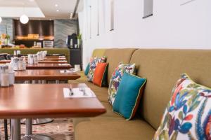 a row of tables in a restaurant with pillows at HF Fénix Garden in Lisbon