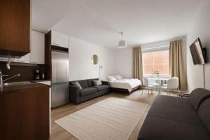 a living room with a couch and a table at Tammer Huoneistot - City Suite 2 - City View & Perfect location in Tampere