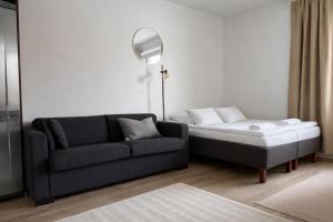 a living room with a couch and a bed at Tammer Huoneistot - City Suite 2 - City View & Perfect location in Tampere