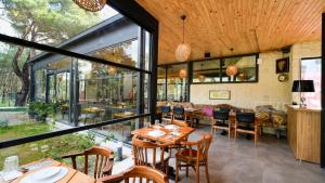 a dining room with tables and chairs and windows at Garrya Romo Hotel in Urla