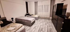 a bedroom with two beds and a flat screen tv at Levu Lak in Kapuvár