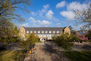 a large brick building with trees in front of it at Hotel Parkzicht Eindhoven in Eindhoven