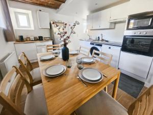 a kitchen with a wooden table with plates and utensils at Appartement Confortable à Coulommiers avec Jardin in Coulommiers