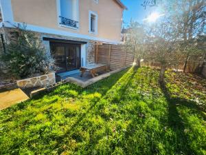 a backyard with a bench and a house at Appartement Confortable à Coulommiers avec Jardin in Coulommiers