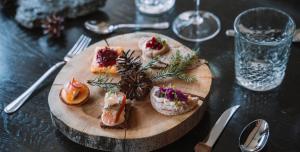 a wooden plate of food on a table at Lapland Hotels Kuopio in Kuopio