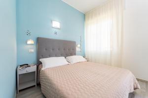 a bedroom with a large bed and a blue wall at Amadei Hotel Promenade in Pesaro