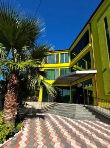 a building with a palm tree in front of it at DeltaHotel in Ureki