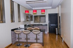 a kitchen with a bar with stools and a counter at Fallsway Palms in Lusaka