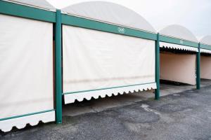 a row of white nets in a parking lot at Hotel Maxim in Peschiera Borromeo