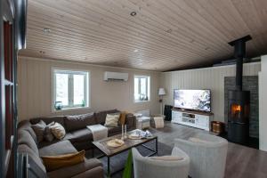 a living room with a couch and a tv at Skoglund privat Villa in Trysil