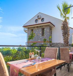 a table and chairs on a balcony with a house at Azure Palm Resort in Oludeniz