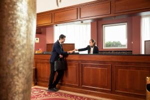a man and a woman standing at a bar at Hotel Maxim in Peschiera Borromeo