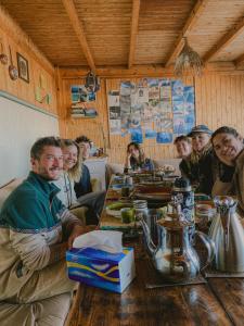 a group of people sitting at a table in a restaurant at Dania Surf House in Mirleft