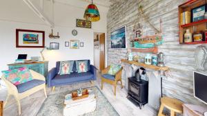 a living room with a fireplace and a wooden wall at E41 Silver Mist, Riviere Towans in Hayle