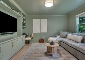 a living room with a couch and a flat screen tv at Villa Montauk Mist in East Hampton