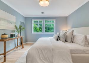 a bedroom with a white bed and a window at Villa Montauk Mist in East Hampton +30 photos