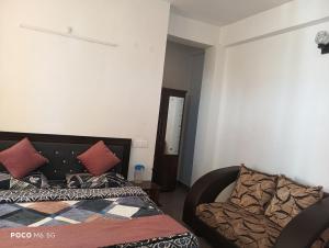 a bedroom with a bed and a couch at Dhananjay home stay in Dharampur