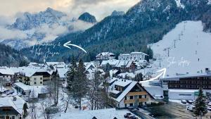 a town with snow covered buildings and a mountain at Vila Mojca SKI IN&OUT - Apartmaji Lena in Kranjska Gora +69 photos