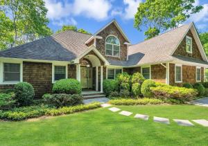 a house with a green lawn in front of it at Villa Montauk Mist in East Hampton