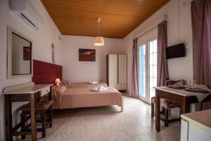 a bedroom with a bed and a desk in a room at Akis Villa Studios & Apartment with Pool by Hotelius in Agios Georgios Pagon