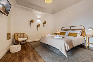 a bedroom with a large bed and a chair at Casa Soure Suites and Apartments in Évora