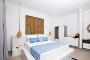 a white bedroom with a bed and a bath tub at Lindos Portes Blue in Lindos