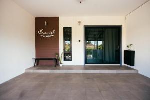 a building with a bench in front of a door at Kawish House กาวิส เฮ้าส์ in Ban Hua Trut