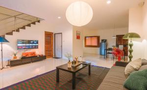 a living room with a couch and a table at Kawish House กาวิส เฮ้าส์ in Ban Hua Trut