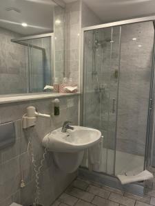 a bathroom with a sink and a shower at Hotel Kronprinz Garni in Minden