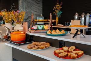 a buffet with plates of bread and pastries on a counter at HF Fénix Garden in Lisbon +11 photos
