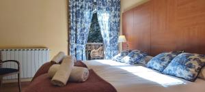 a bedroom with a large bed with blue and white pillows at Hotel Saurat in Espot