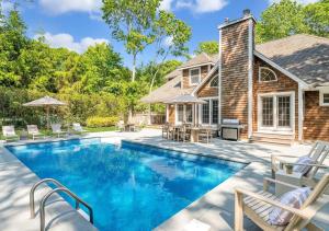 a swimming pool in front of a house at Villa Montauk Mist in East Hampton